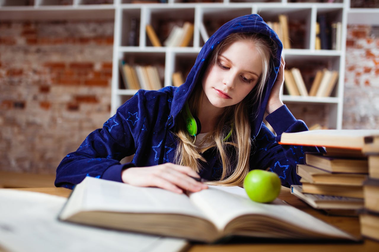 A student preparing for exams with books and notes.
